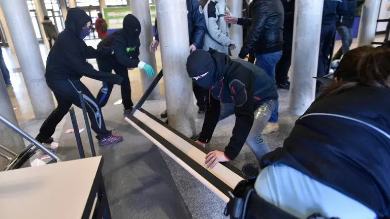 Empleados de seguridad de la UPNA desbloquean la barricada colocada por los manifestantes de Ikasle Abertzaleak para tratar de impedir el acceso al centro. PABLO LASAOSA
