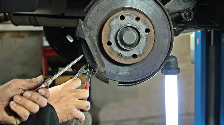 Un hombre arregla un coche en un taller. ARCHIVO