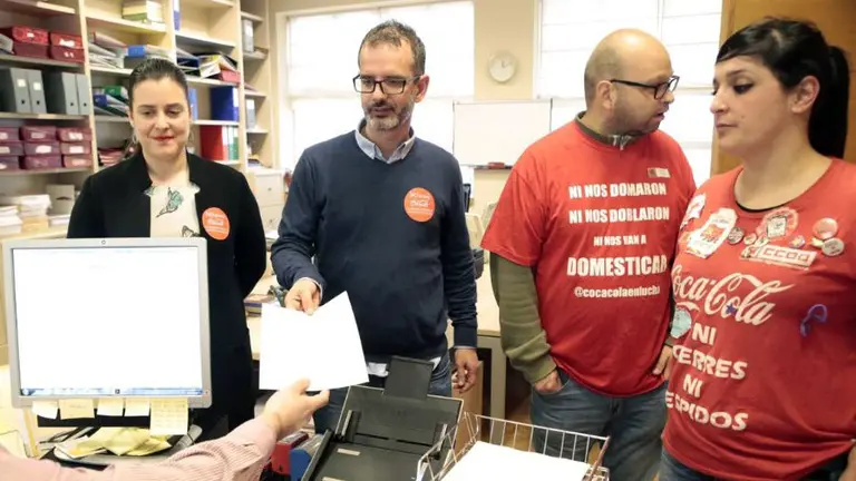 El senador navarro Iñaki Bernal, entrega el documento junto a trabajadores de Coca Cola..