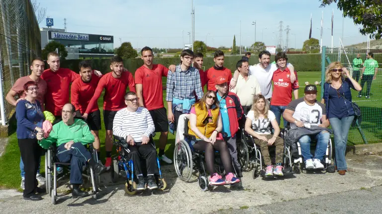 Miembros de Acodifna, en Tajonar junto a un grupo de jugadores de Osasuna.