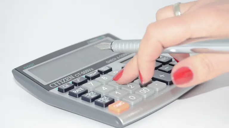 Una mujer utilizando una calculadora.