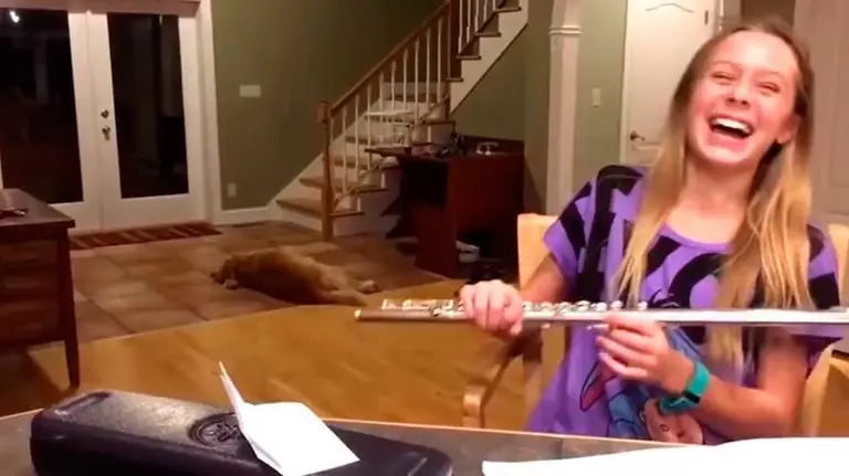 La joven practica con la flauta travesera mientras el can se va enfadando. YOUTUBE