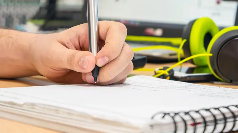 Una persona escribe en un cuaderno de anillas