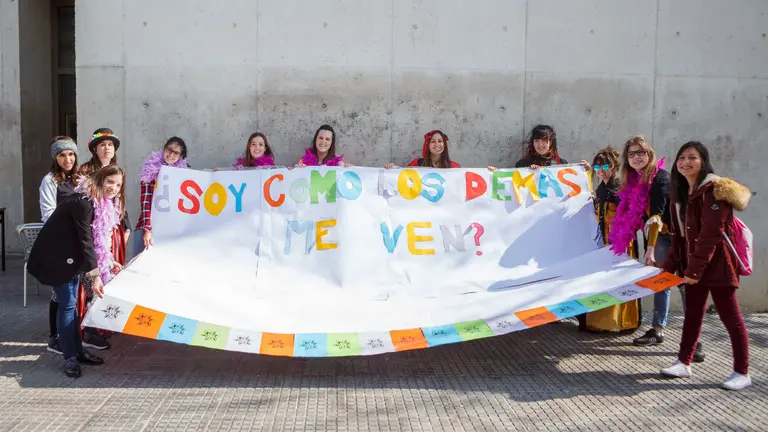 Integrantes de la Escuela de Agentes de Mediación en Salud posan junto con el mural reivindicativo en la UPNA.
