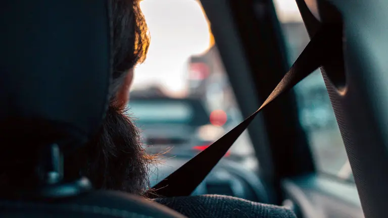 Una persona en un vehículo con el cinturón de seguridad abrochado