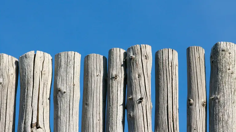 Una valla blanca de madera en una foto de archivo.