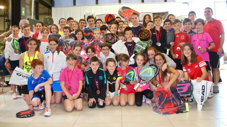 Grupo de campeones escolares de pádel.