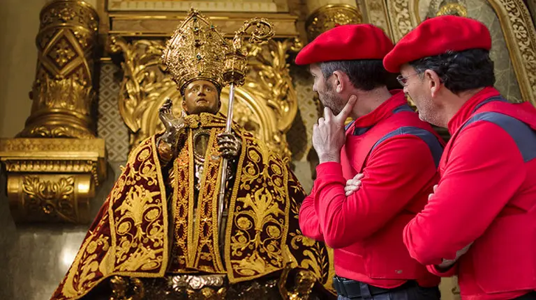 Imagen de San Fermín y junto a la fotografía de dos agentes de la Policía Foral. NAVARRA.COM