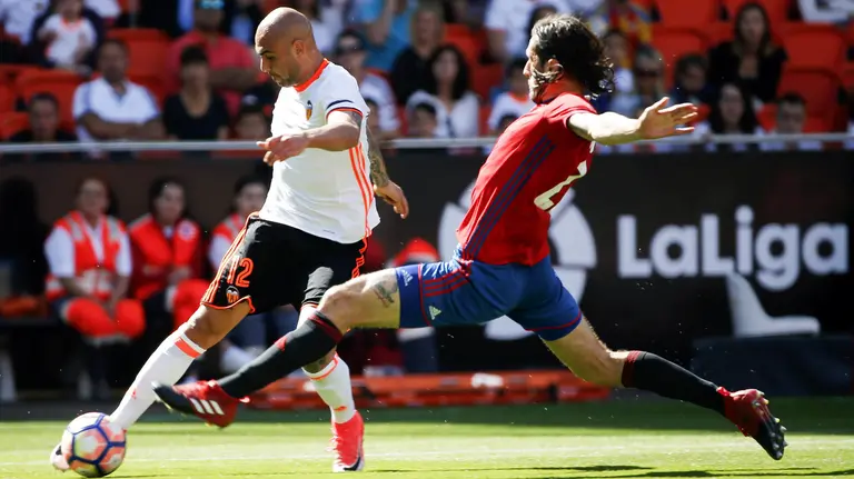 El delantero italiano del Valencia Simone Zaza (i) y el defensa montenegrino del Osasuna, Nikola Vujadinovic, durante el partido de la trigésima sexta jornada de Liga que disputan en el estadio de Mestalla. EFE/Kai Försterling