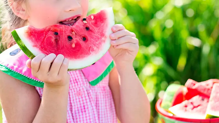 Una niña come una raja de sandía. ARCHIVO