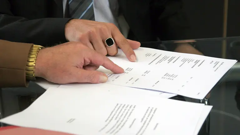 Dos personas consultan unos documentos