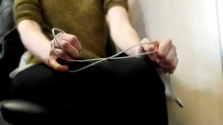 Mujer con un cable de teléfono en las manos. ARCHIVO