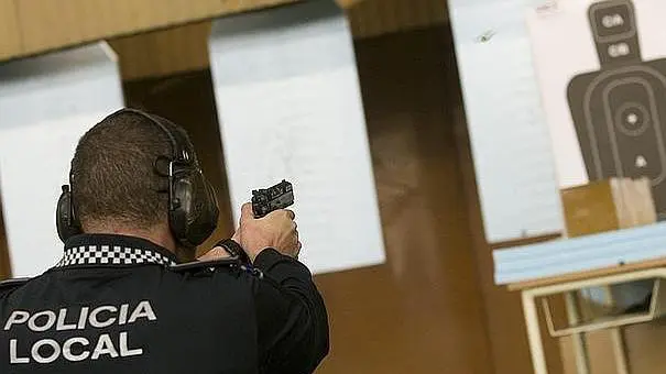 Un policía local realiza pruebas de tiro sobre una diana