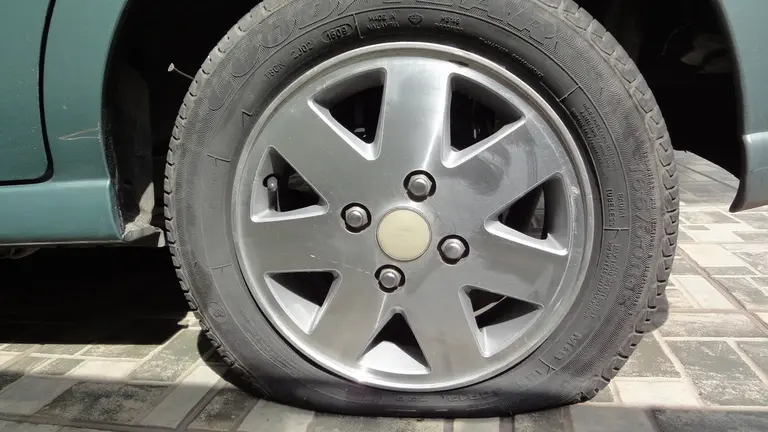 La rueda pinchada de un vehículo, estado en el que trataron de escapar los conductores del coche que transportaba hachís.