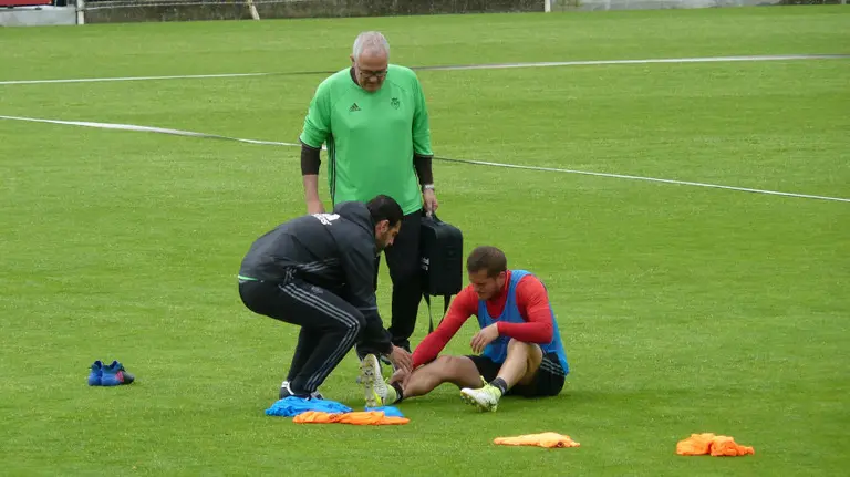 Causic en el suelo doliéndose del tobillo.