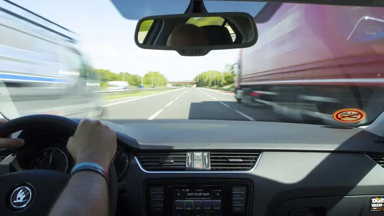Un hombre conduce un vehículo por la autopista.