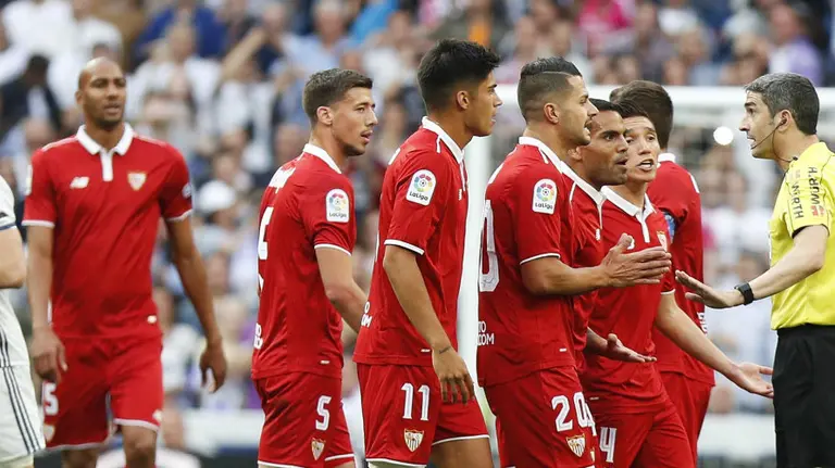 Los jugadores del Sevilla protestan a Undiano Mallenco. Foto web Sevilla CF.
