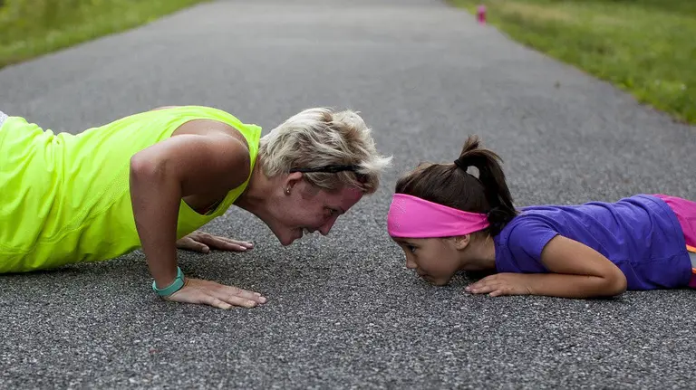 Imagen de une entrenadora junto a una joven alumna practicando flexiones tras una carrera ARCHIVO