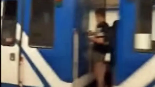 Un joven viajando entre dos vagones