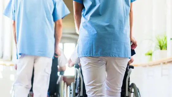Imagen de dos celadores llevando a pacientes en silla de ruedas ARCHIVO