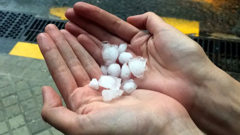 Una persona recoge las pelotas de granizo que han caído sobre la Comarca de Pamplona.