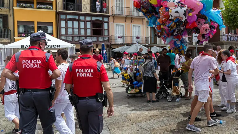 La Policía Foral pasa delante de un puesto de venta ambulante de globos en el dispositivo de seguridad de Sanfermines durante el Chupinazo de 2017. IÑIGO ALZUGARAY