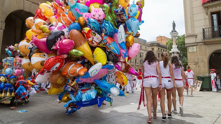 La fiesta en Sanfermines después del Chupinazo de 2017 con un vendedor de globos en los puestos de venta ambulante. IÑIGO ALZUGARAY