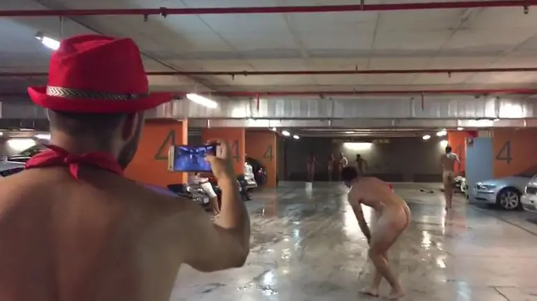La gamberrada de un grupo de jóvenes deslizándose desnudos sobre una pátina de agua y jabón en el parking de Baluarte
