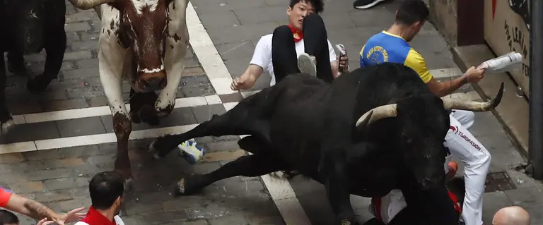 GRA019. PAMPLONA, 10/07/2017.- Los toros de la ganadería de Fuente Ymbro entre un grupo de corredores, a su paso por la calle Estafeta de Pamplona, en el que cuarto encierro de los Sanfermines 2017, el más rápido de estas fiestas, que se ha saldado con al menos dos heridos. EFE/Javier Lizón
