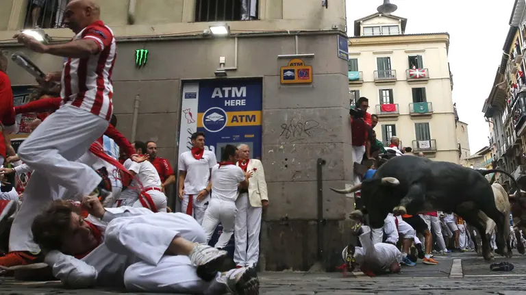 Un toro de la ganadería de Miura, de Lora del Río (Sevilla), a su paso por la curva de Mercaderes en el último encierro de los Sanfermines. EFE/Javier Lizón