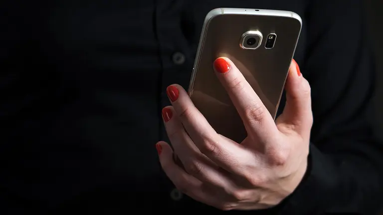 Una mujer con un teléfono móvil.