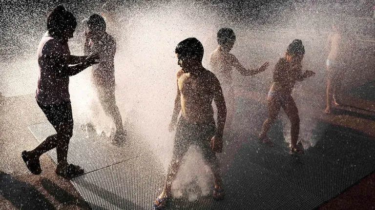 Varios niños se divierten en una de las fuestes del parque Yamagutxi en Pamplona. EFE.