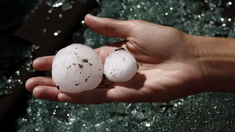 Una mujer muestra las bolas de granizo del tamaño de un huevo, caídas durante la fuerte tormenta que ha azotado esta noche la comarca de Sangüesa y ha dejado importantes daños materiales en los municipios de Liédena, Yesa y Sangüesa. Las lunas de varios vehículos han quedado completamente rotas tras el impacto sufrido, por el tamaño del granizo. EFE/Jesús Diges