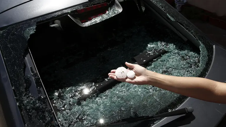 Una mujer muestra las bolas de granizo del tamaño de un huevo, caídas durante la fuerte tormenta que ha azotado esta noche la comarca de Sangüesa y ha dejado importantes daños materiales en los municipios de Liédena, Yesa y Sangüesa. Las lunas de varios vehículos han quedado completamente rotas tras el impacto sufrido, por el tamaño del granizo. EFE/Jesús Diges