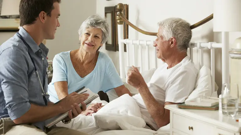 Un hombre recibe atención médica en su casa a través de un servicio de hospitalización a domicilio