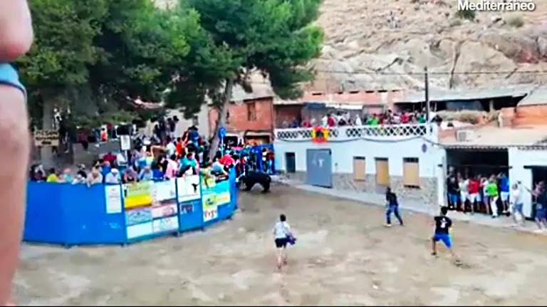 Momento en el que el toro arremete contra el corredor