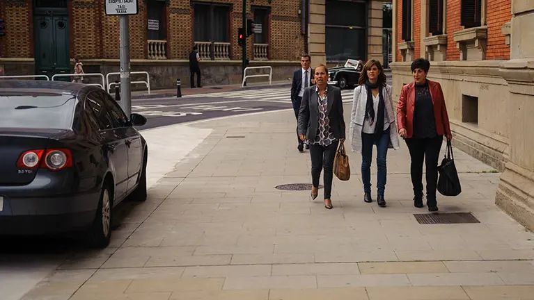 La presidenta Barkos y la portavoz del Gobierno, María Solana, acceden al Parlamento con el coche oficial subido en la acera. MIGUEL OSÉS