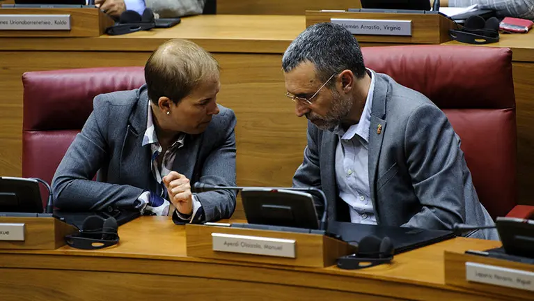 La presidenta del Gobierno Navarro Uxue Barcos charla con Miguel Laparra durante el pleno parlamentario. MIGUEL OSÉS