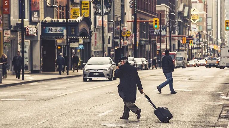 Un hombre con una maleta de viaje en una ciudad.
