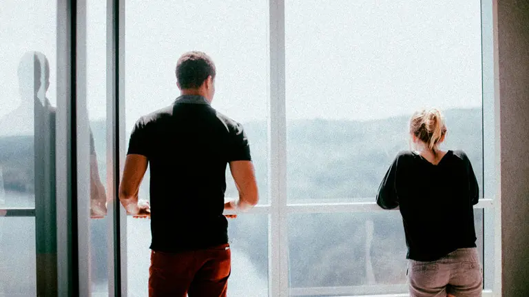 Una pareja mira por la ventana. ARCHIVO