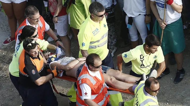 GRA018 FALCES (NAVARRA), 15/08/2016.-Una mujer que se ha precipitado barranco abajo, sufriendo sendos traumatismos torácico y craneoencefálico, con pérdida de consciencia, es trasladada por efectivos de la DYA a la ambulancia tras el segundo encierro del Pilón corrido hoy en la localidad navarra de Falces. La rapidez de las vacas, pertenecientes a la ganadería Teodoro Vergara, de Falces (Navarra), y la cercanía al vallado de alguno de los animales han originado una accidentada carrera. El encierro discurre por un estrecho y escarpado recorrido de 800 metros cuesta abajo, con el muro de la montaña a un lado y el barranco, al otro. EFE/Jesús Diges