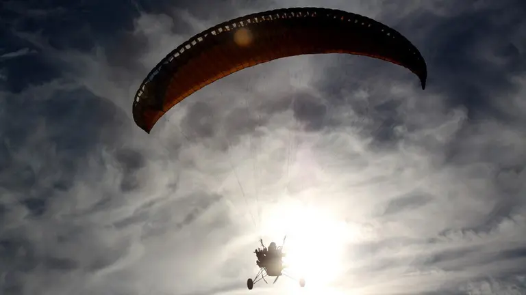 Un hombre volando en paramotor, el tipo de aeronave con la que Emilio Calvo Atienza se accidentó mortalmente en Portugal.