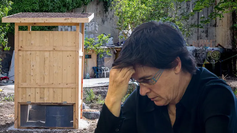 Imagen de la concejal de Acción Social del Ayuntamiento de Pamplona, Edurne Eguino, junto a la letrina instalada en el asentamiento chabolista del Club de Tenis FOTOMONTAJE