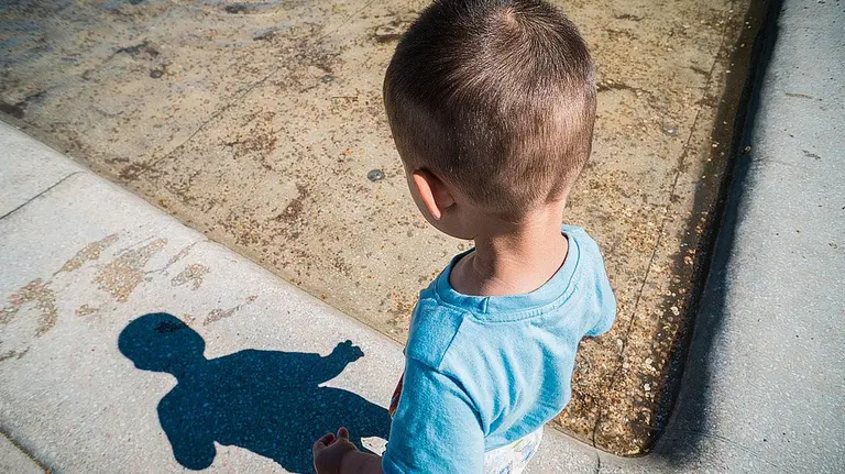 Un niño caminando solo por un parque.