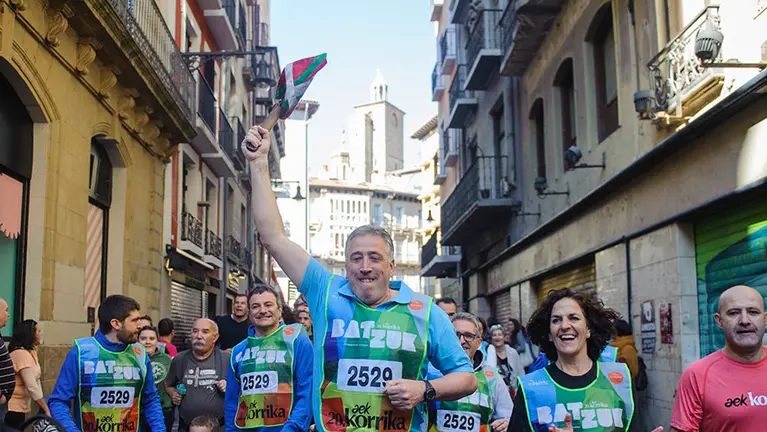 Asirón e Itziar Gómez corren con LA Ikurriña durante la Korrika en Pamplona. MIGUEL OSÉS
