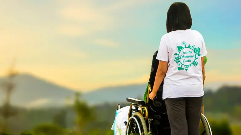 Una mujer lleva una silla de ruedas en una imagen de archivo