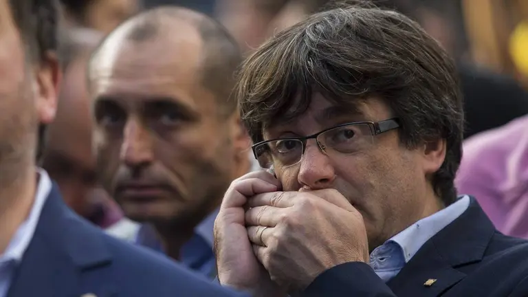 El expresident de la Generalitat de Cataluña, Carles Puigdemont, hablando por teléfono junto al exvicepresidente Junqueras EFE