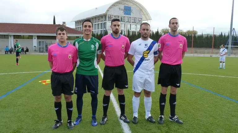 Trio arbitral y capitanes en el partido Iruña - Cantolagua.