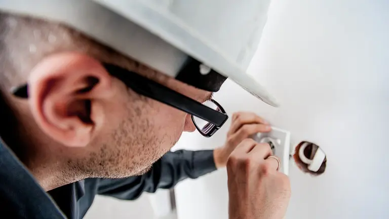 Un electricista arregla un enchufe. ARCHIVO