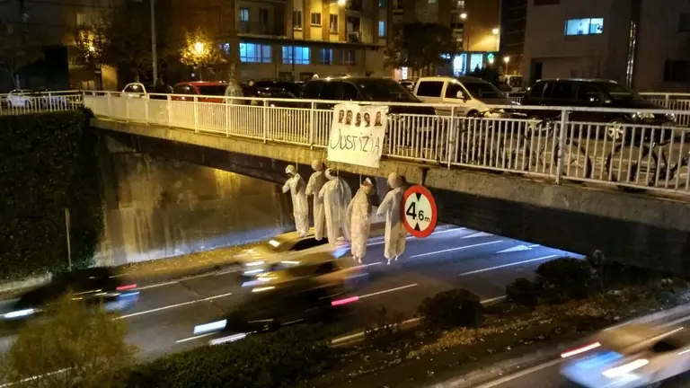 Cinco muñecos que simulan a los cinco miembros de La Manada colgados en el puente de San Juan en Pamplona